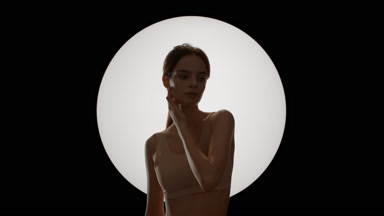 Attractive slim woman with ponytail strokes jawline turning head