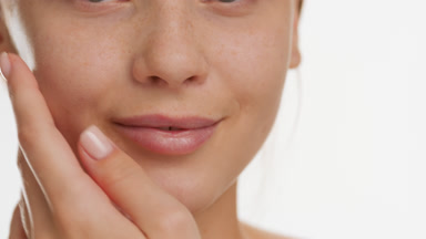 Gorgeous Caucasian woman strokes jawline looking at the camera