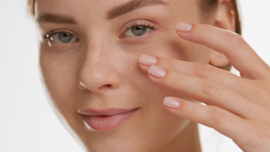 Pretty Caucasian woman strokes cheek turning head to the camera