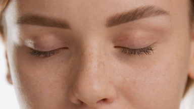 Good-looking Caucasian woman opens her eyes and looks at camera