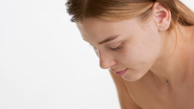 Attractive young slim woman with long brown hair washes her face