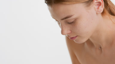Beautiful young slim woman with long brown hair washes her face