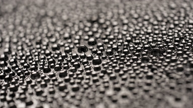 Water drops appear from shadow for a while on black background