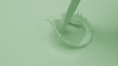Macro of green liquid is poured splashing on green background