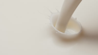 Macro shot of white liquid is poured and dripped splashing