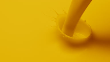 Macro shot of yellow liquid is poured and dripped splashing