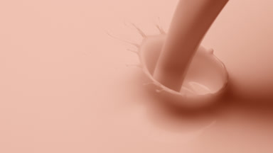 Macro shot of beige liquid is poured and dripped splashing