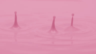 Macro jib shot of pale pink opaque liquid is dripped splashing