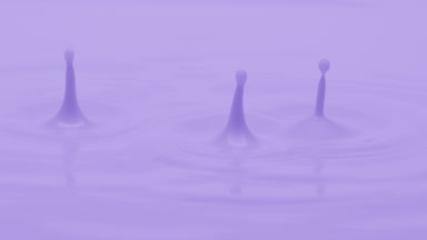 Macro jib shot of purple opaque liquid is dripped splashing