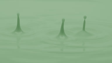 Macro jib shot of green opaque liquid is dripped splashing