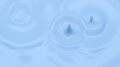 Macro jib shot of pale blue opaque liquid is dripped splashing