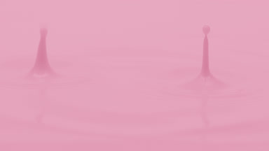 Pink liquid is dripped creating ripples on pink background