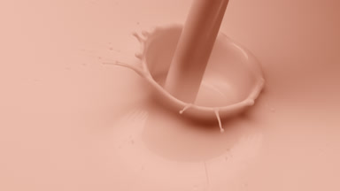 Beige liquid is poured creating bubbles on beige background
