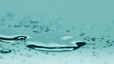 Small drop falls down near big one merging on cyan background