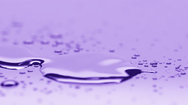 Small drop falls down near big one merging on violet background