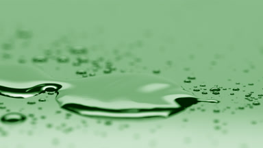 Small drop falls down near big one merging on green background