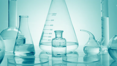 Drops drip in bottle surrounded by glassware on cyan background