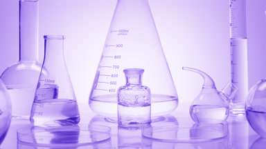 Drops drip in bottle surround by glassware on purple background
