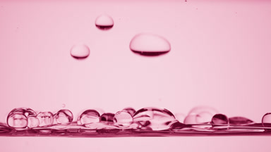 Bubbles float to the surface bouncing off it on pink background