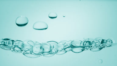 Transparent bubbles go down to the surface on cyan background