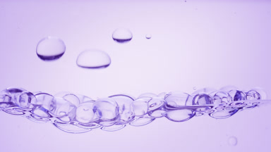 Transparent bubbles go down to the surface on purple background