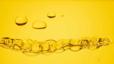 Transparent bubbles go down to the surface on yellow background