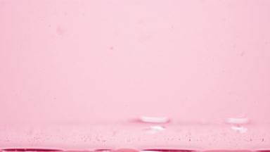 Different sized bubbles go down to surface on pink background