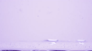 Different sized bubbles go down to surface on purple background