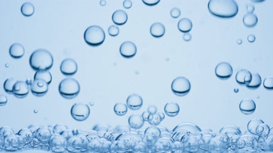Bubbles of hyaluronic acid go down to surface on blue background