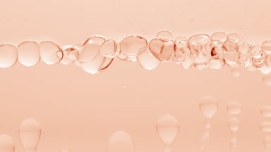 Clear bubbles form and float to another on beige liquid surface
