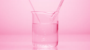 Dropper drips liquid which sink in beaker on pink background