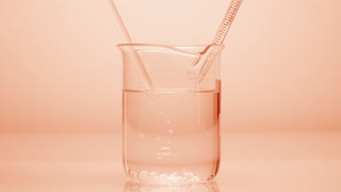 Dropper drips liquid which sink in beaker on beige background