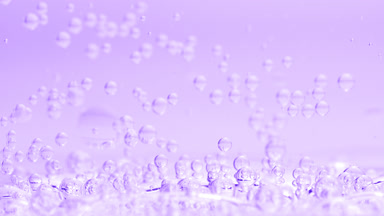 Bubbles sink to liquid surface with another on purple background