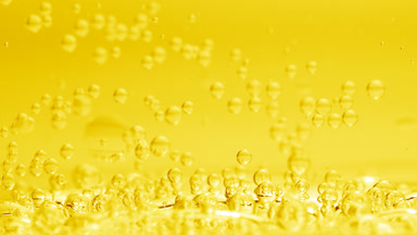 Bubbles sink to liquid surface with another on yellow background