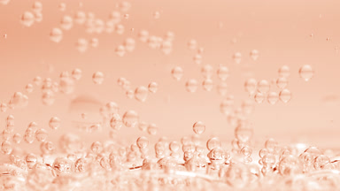 Bubbles sink to liquid surface with another on beige background