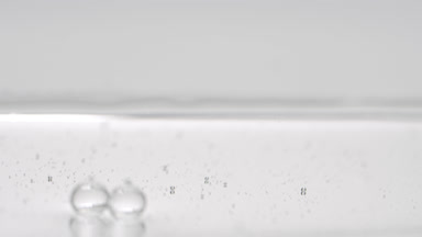 Macro of grey bubbles sink to liquid surface on grey background