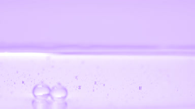 Purple bubbles sink to the liquid surface on purple background