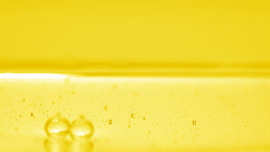 Yellow bubbles sink to the liquid surface on yellow background