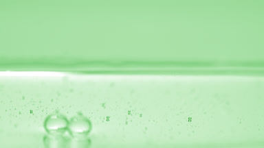 Green bubbles sink to the liquid surface on green background