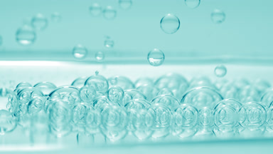 Cyan transparent bubbles sink to fluid surface with another ones