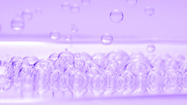 Purple transparent bubbles sink to fluid surface with another