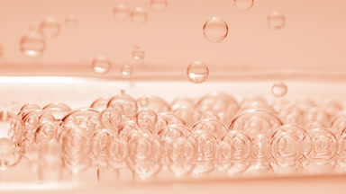 Beige transparent bubbles sink to the fluid surface with another