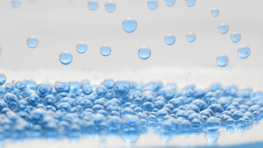 Blue transparent bubbles fall down to another on grey background