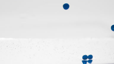 Dark-blue bubbles sink to the liquid surface on grey background