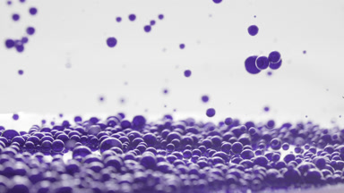 Dark-blue opaque bubbles sink to the liquid surface with another