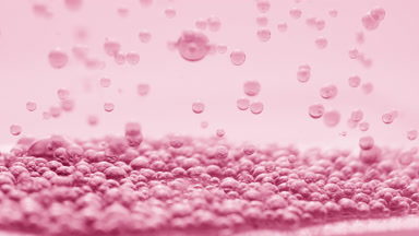 Pink transparent bubbles sink to another ones on pink background