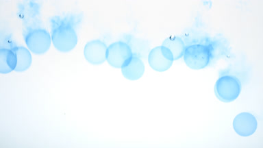 Blue circles being poured in water and sink on white background