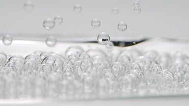 Grey clear bubbles sink to another ones on grey background