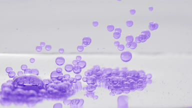 Purple clear bubbles sink to liquid surface on grey background