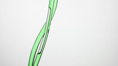 Hemp oil is flowing down in connecting tubes on grey background